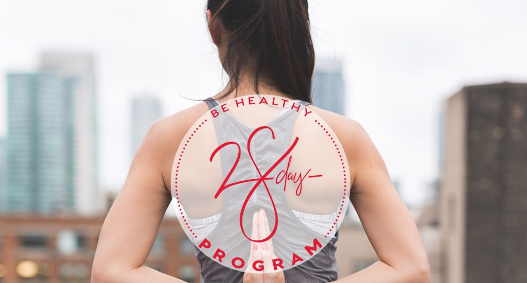 Woman stretching on rooftop with 28 Day RESET logo