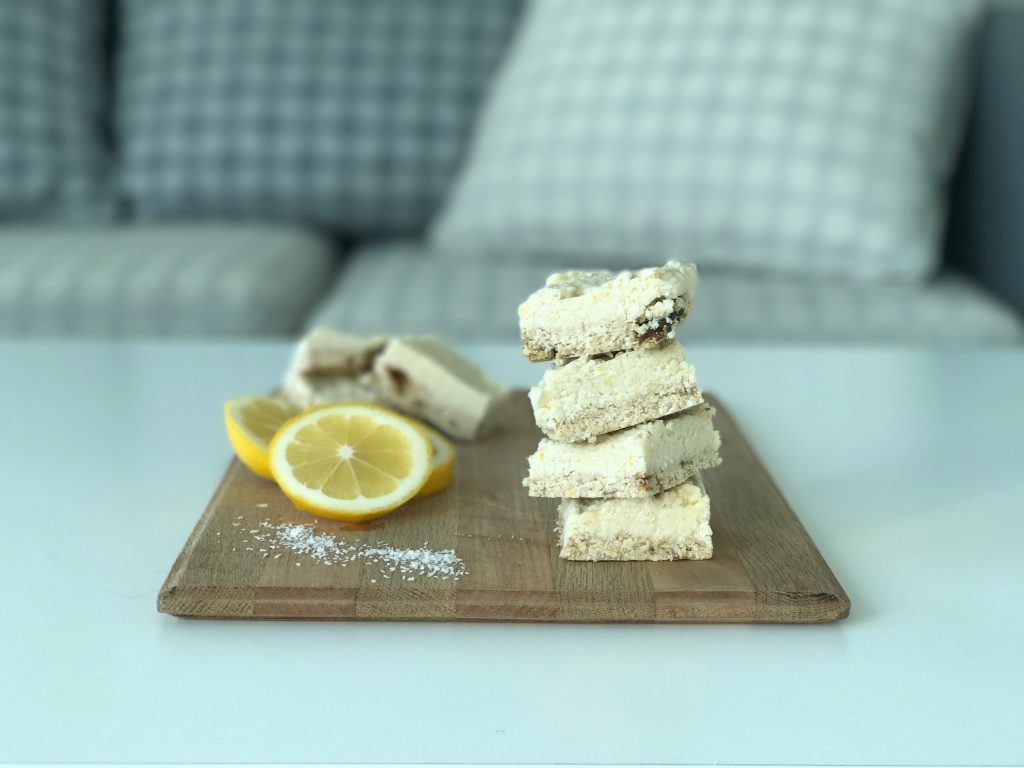 raw lemon slice nn a chopping board with lemons and sprinkled desiccated coconut